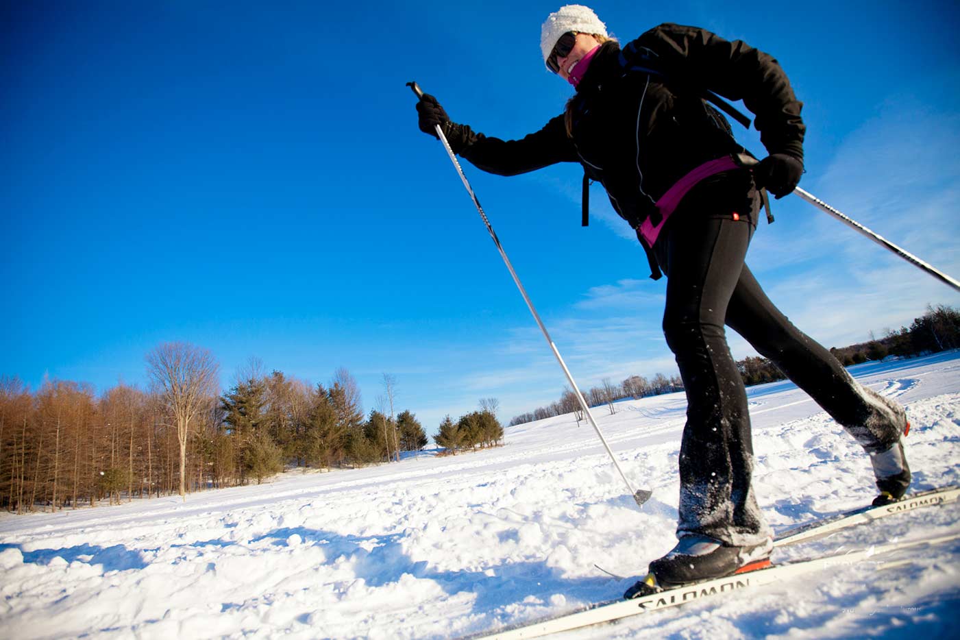 Woman skiing across a frozen lake near Algonquin Park