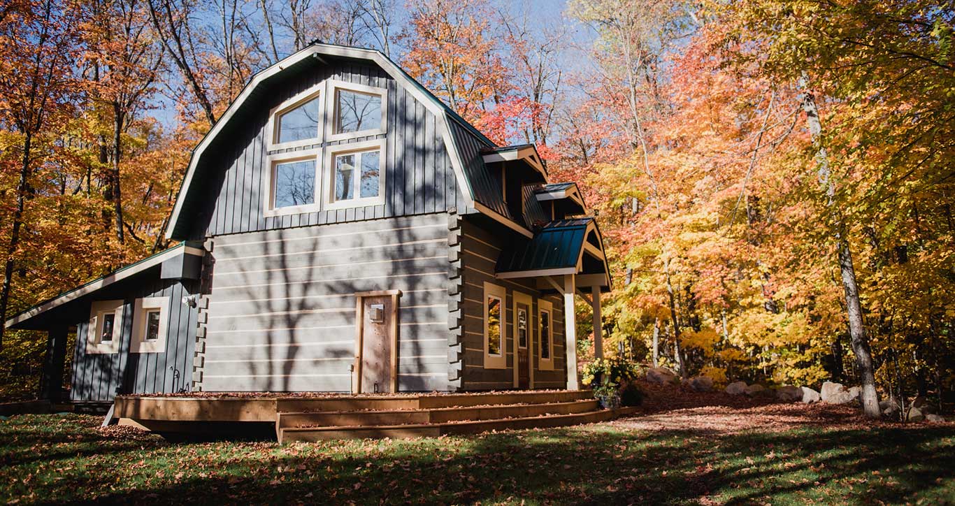 Beautiful log cabin surrounded by fall foliage in the woods
