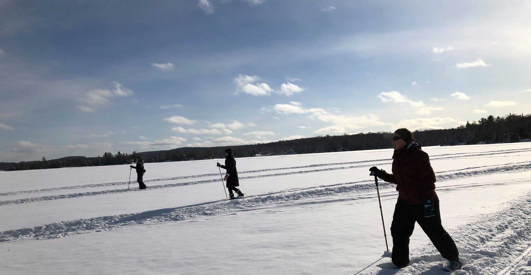A group skiing across the frozen lake in unison