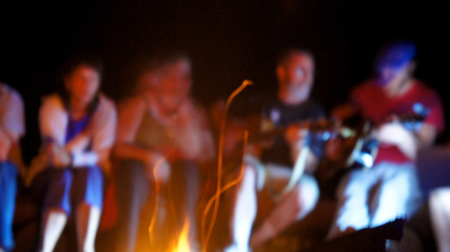 A group sitting around the fire sharing ideas and music